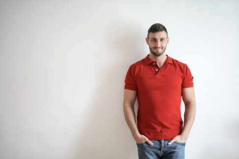 man in red polo shirt and blue denim jeans